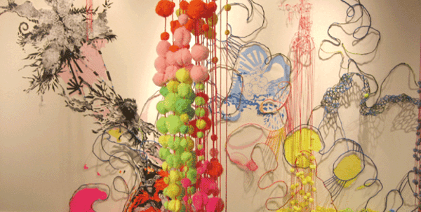 hanging sculpture in front of wall drawings